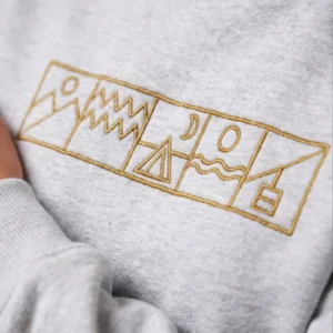 Gros plan de la broderie du sweat Lifestyle Outdoor Heather Grey de NOWFIELD.