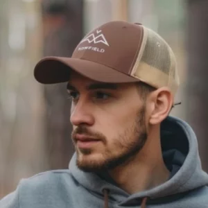 Casquette trucker NOWFIELD coloris marron et kaki portée dans un environnement outdoor.